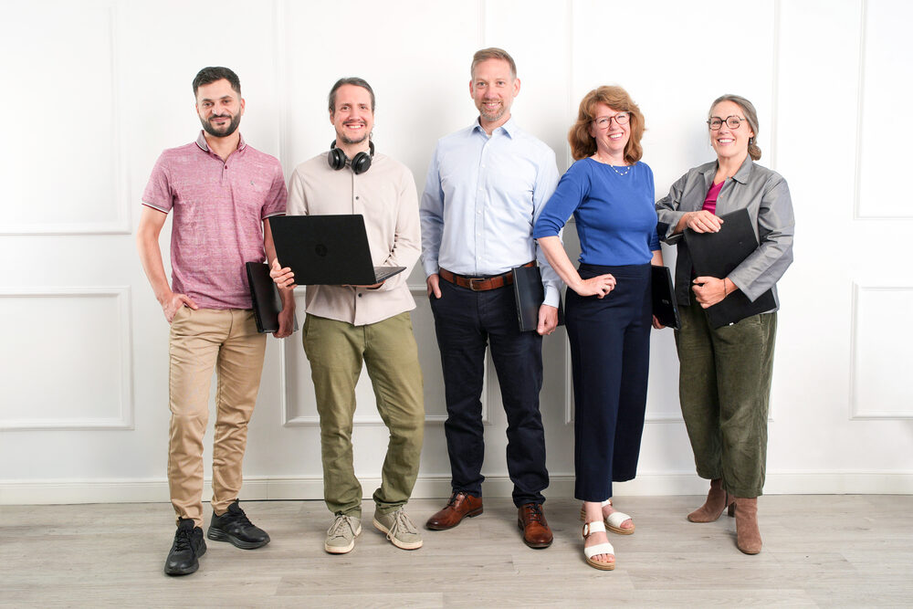 Team von digital@work mit Laptop und Arbeitsmaterialien